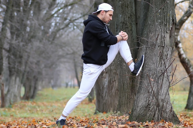 Yoga man sport in herfst park zit op een mat