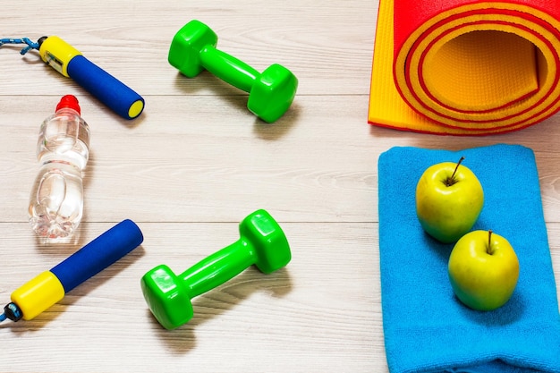 Yoga mat and different tools for fitness on floor in room