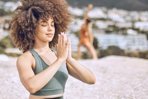 Yoga-meditatie en zwarte vrouw aan het strand voor fitnesstraining en wellness Motivatietraining en vrouw die op zomerochtend aan de oceaan traint voor kalmte, rust en vrede om te mediteren in de natuur