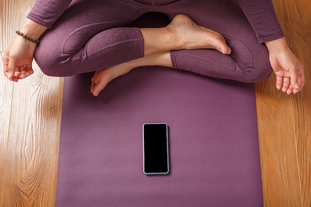 Yoga online training workout per smartphone, met behulp van de fitness-app thuis in de sportschool. Online yoga- en meditatieoefeningen. Plaats op het smartphonescherm