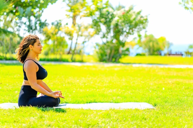 Yoga outdoors woman doing yoga in summer green park at sunny day