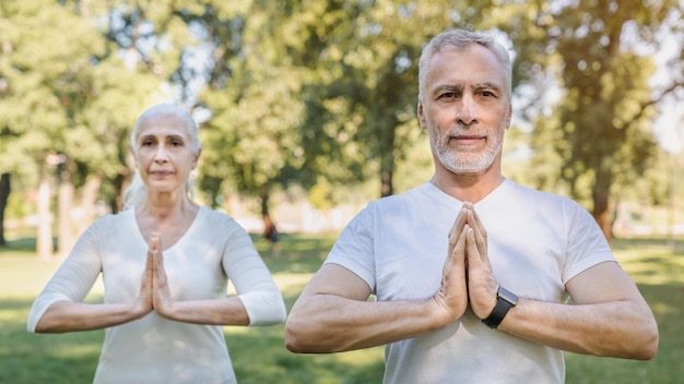 Photo yoga at park senior family couple exercising outdoors