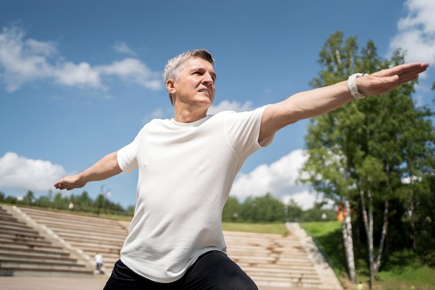 Yoga pose asana old man gray hair fitness workout in the park exercise