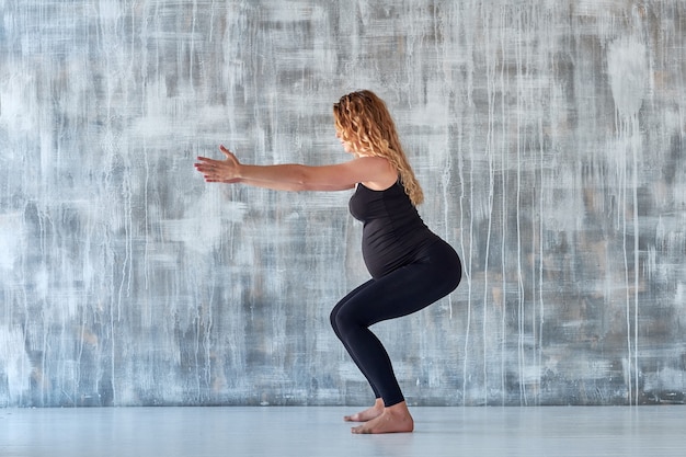 Yoga. Pregnant woman practicing yoga meditation in studio. Health lifestyle concept and baby care