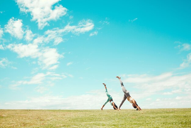 Yoga stretching and women training on a field for spiritual wellness freedom and zen together in nature Friends doing a meditation exercise for fitness balance and mind health in a park in Norway