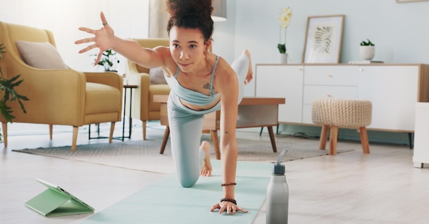 Photo yoga tablet and woman with online video for stretching exercise in the living room of her house girl with balance during fitness workout on the internet with tech in the lounge of her home