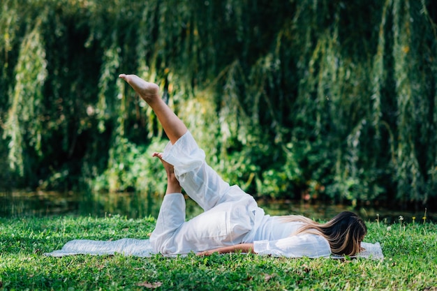 Yoga vrouw doet yoga aan het meer