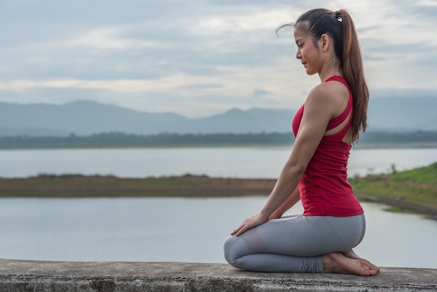 ヨガの女性は運動をする前に瞑想を立地します。