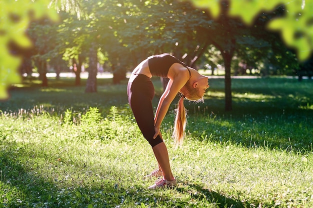 Yoga giovane donna che pratica yoga o balla o si allunga nella natura al parco concetto di stile di vita di salute