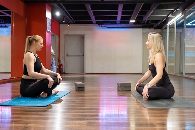 Yogaleraar student groepsles beoefenen van yoga lesgeven bewegingen die zich uitstrekken in studio