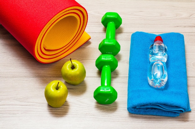 Yogamat en verschillende hulpmiddelen voor fitness op de vloer in de kamer