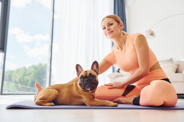 Yogatijd Vrouw met mopshond is overdag thuis