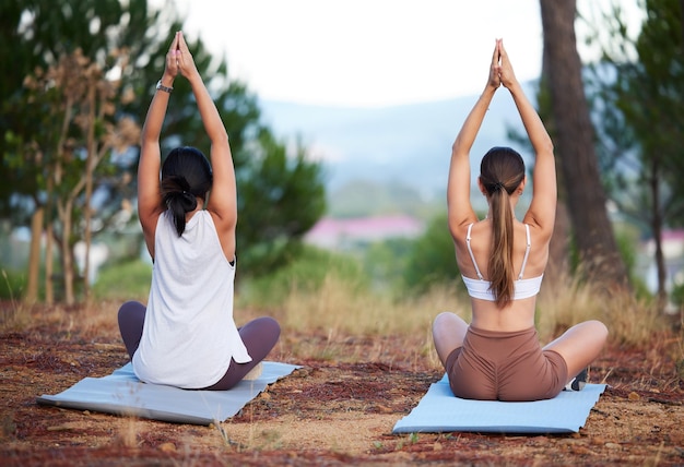 Yogavrouwen buiten en meditatie in de natuur voor fitnessoefeningen en wellness Vrienden samen in een bos voor een training training en energie voor geestelijke gezondheid vrede en zen met handen in gebed