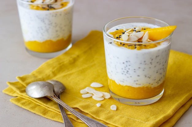 Yoghurt in een glas met mango, chia en amandelen. gezond eten. vegetarisch eten. recept. ontbijt. eetpatroon.