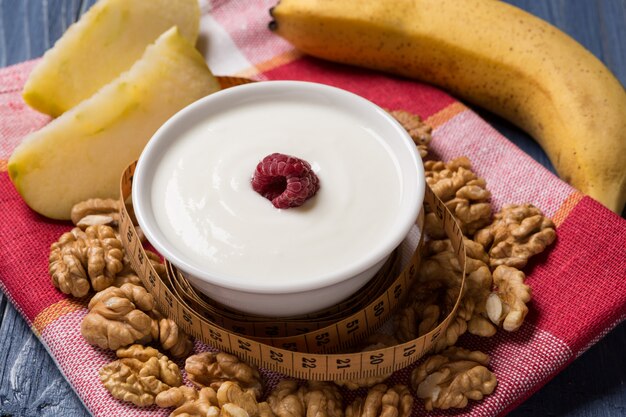 Yoghurt in een pial versierd met frambozen, noten en fruit, concept van gezond eten