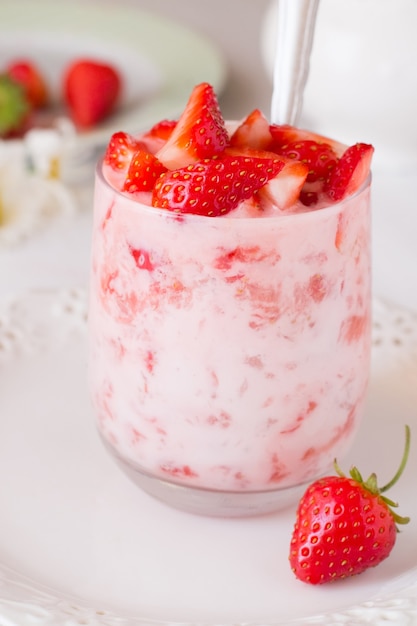 Yoghurt met aardbei in glas op houten tafel