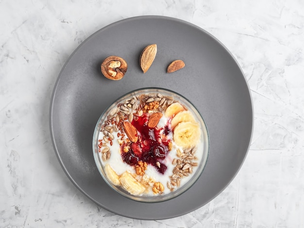 Yoghurt met granola, noten en kersenjam in een kom