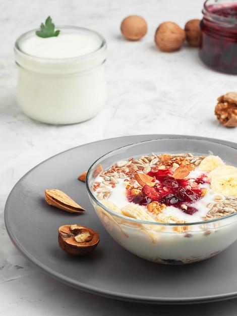 Yoghurt met granola, noten en kersenjam in een kom