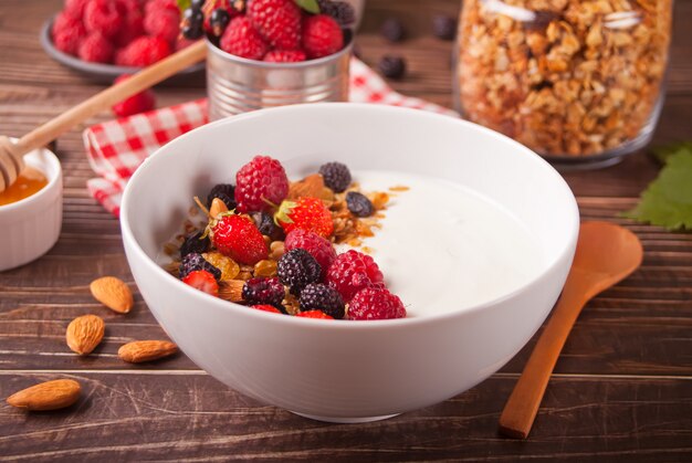 Yoghurt met verse bessen, muesli havermout muesli op de houten tafel.