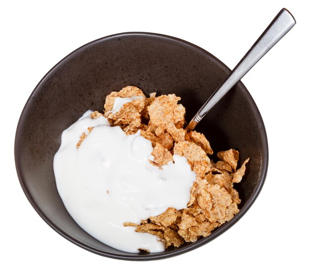 Yogurt e cucchiaio nella ciotola di cereali