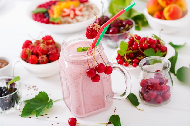Yoghurt-strawberry smoothies in a jar on a white table