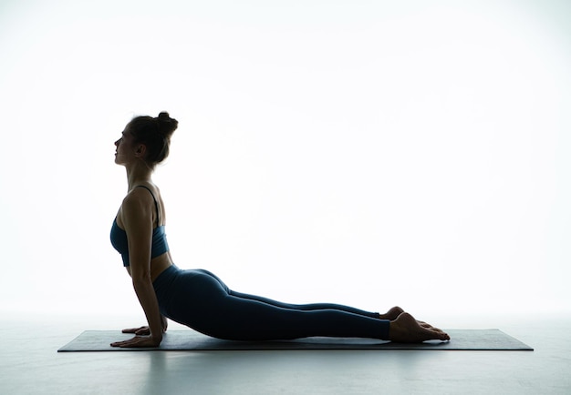 Yogi young girl practicing yoga exercising perform cobra pose stretching body muscles for wellness