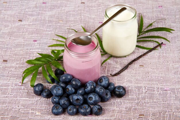 Yogurt and blueberries on pink cloth