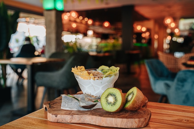 Yogurt bowl with fruits such as kiwi and pineapple, chia, dried fruits and crunchy muesli.