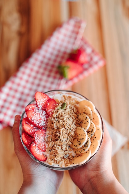 Yogurt bowl with fruits such as strawberry and banana, chia, dried fruits and crunchy muesli.