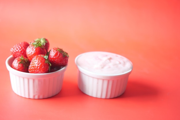 Yogurt and strawberry in a bowl on white