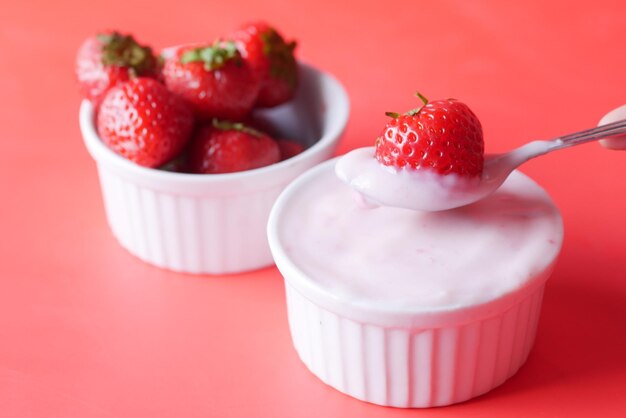 Yogurt and strawberry in a bowl on white