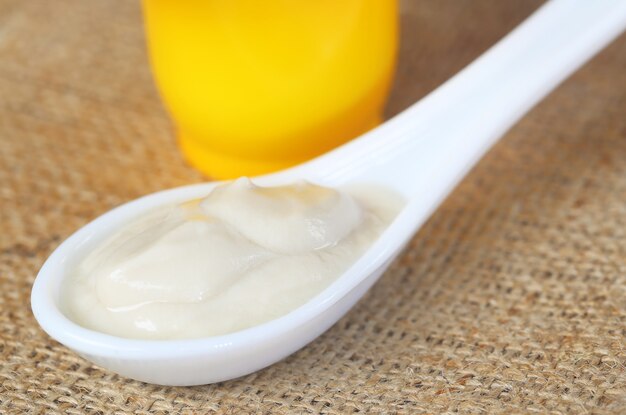 Foto yogurt o cagliata dolce su cucchiaio bianco