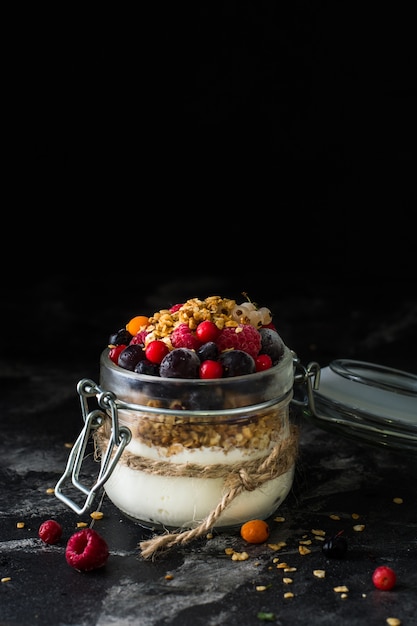 Yogurt with baked granola and berries in jar