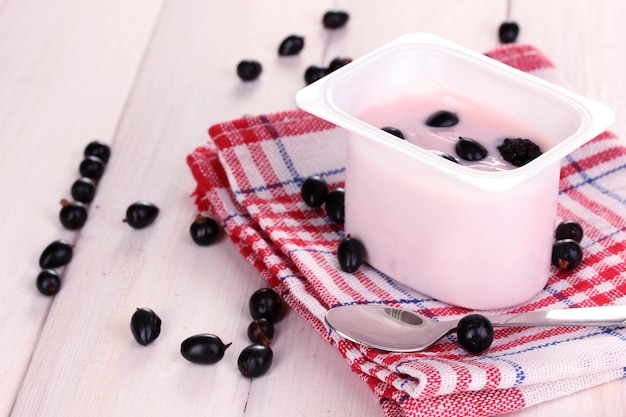 Йогурт с ягодами на деревянном фоне