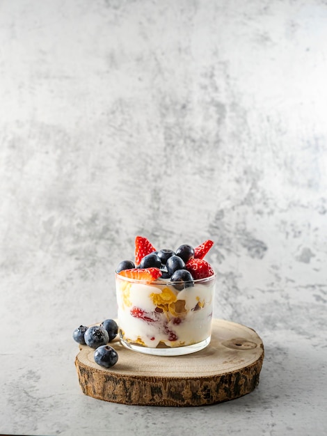 Yogurt with cereals strawberries and fresh blueberries in a glass jar A healthy breakfast Copy space