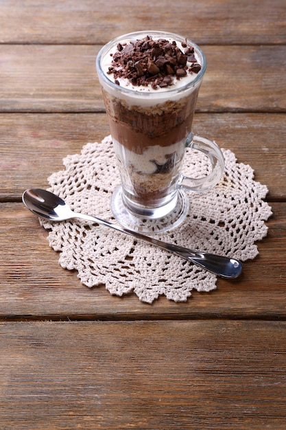 写真 チョコレートクリームのみじん切りチョコレートとミューズリーとヨーグルトは、木製の背景にガラスで提供