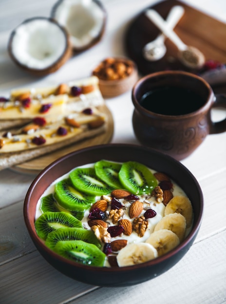 Yogurt with different fruits on a wooden table. Useful food, diet, organic.