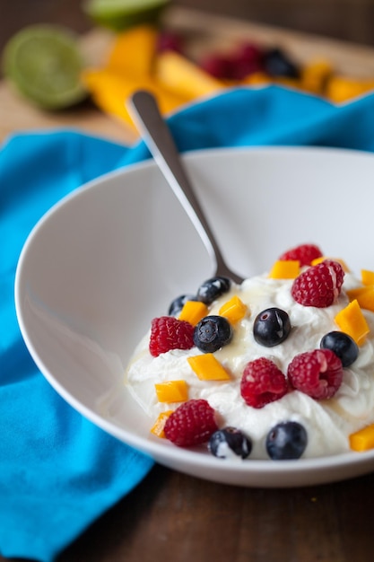 Photo yogurt with garnishing of raspberries and blueberries in bowl