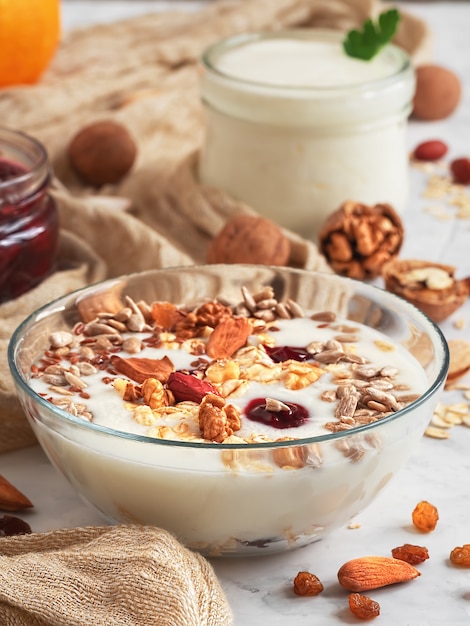 Yogurt with granola, nuts and cherry jam in a bowl