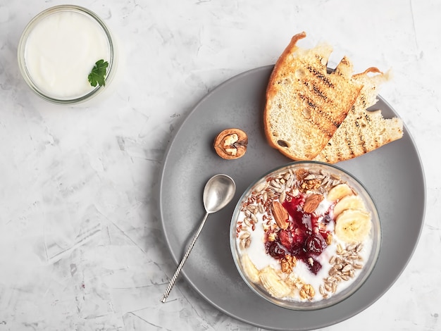 Photo yogurt with granola, nuts and cherry jam in a bowl