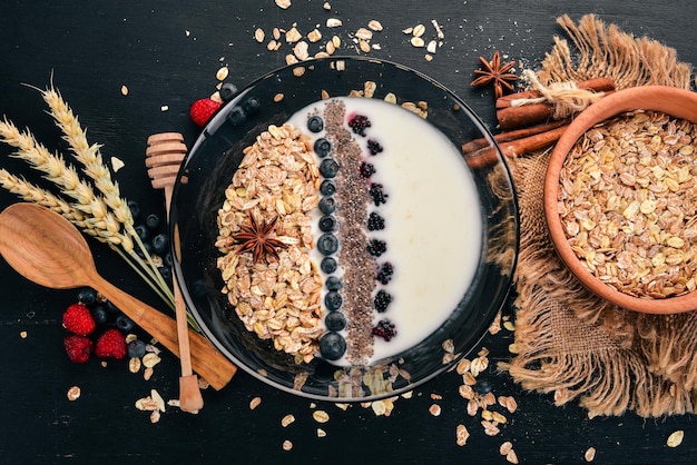 Yogurt with oatmeal and blueberries and blackberries Chia seeds Breakfast On a wooden background Top view Free space for text