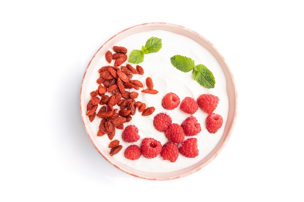 Yogurt with raspberry and goji berries in ceramic bowl