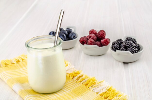 Yogurt with red berries in the glass bowl