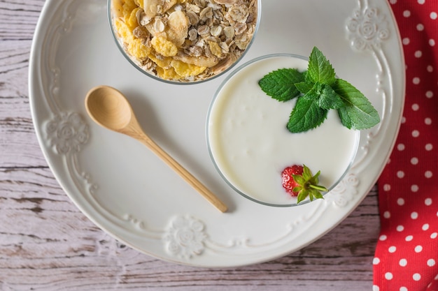 Yogurt con fragole e menta e farina d'avena su un tavolo di legno