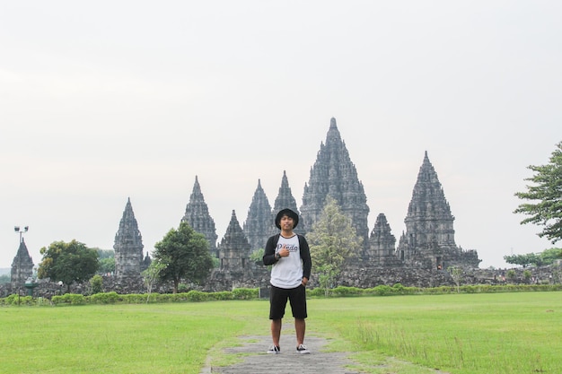Yogyakarta July 2021 Young man posing with Prambanan Temple in the background