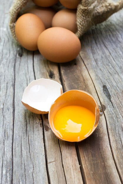 Yolk of egg in egg shell. On wooden background.