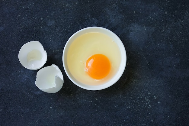 Photo yolk and white in a plate and eggshell