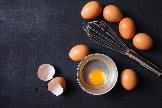  Yolks and egg protein in a cup. Corolla whisk eggs. Preparation of food and chicken eggs