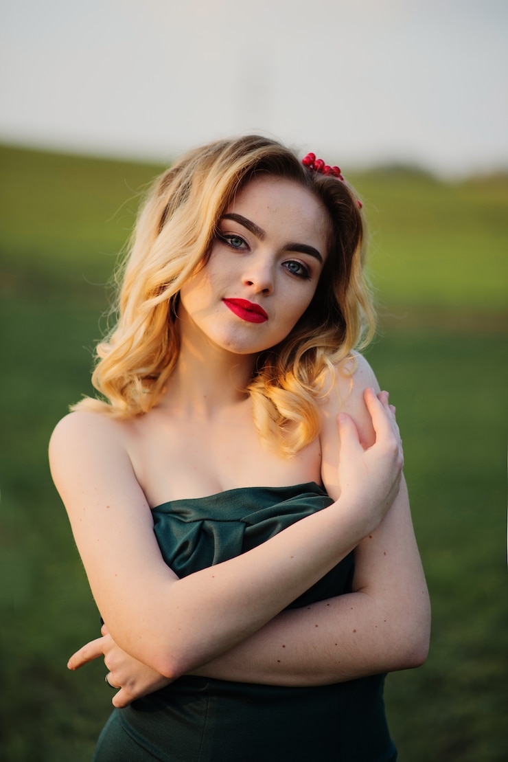 Photo yong elegant blonde girl at green dress on the garden in spring.