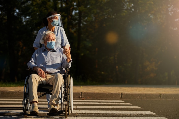 Yong-medicijnmedewerker die tijd doorbrengt met oudere gehandicapte man